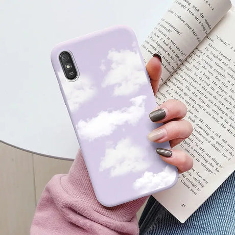 a woman holding a book and a phone case