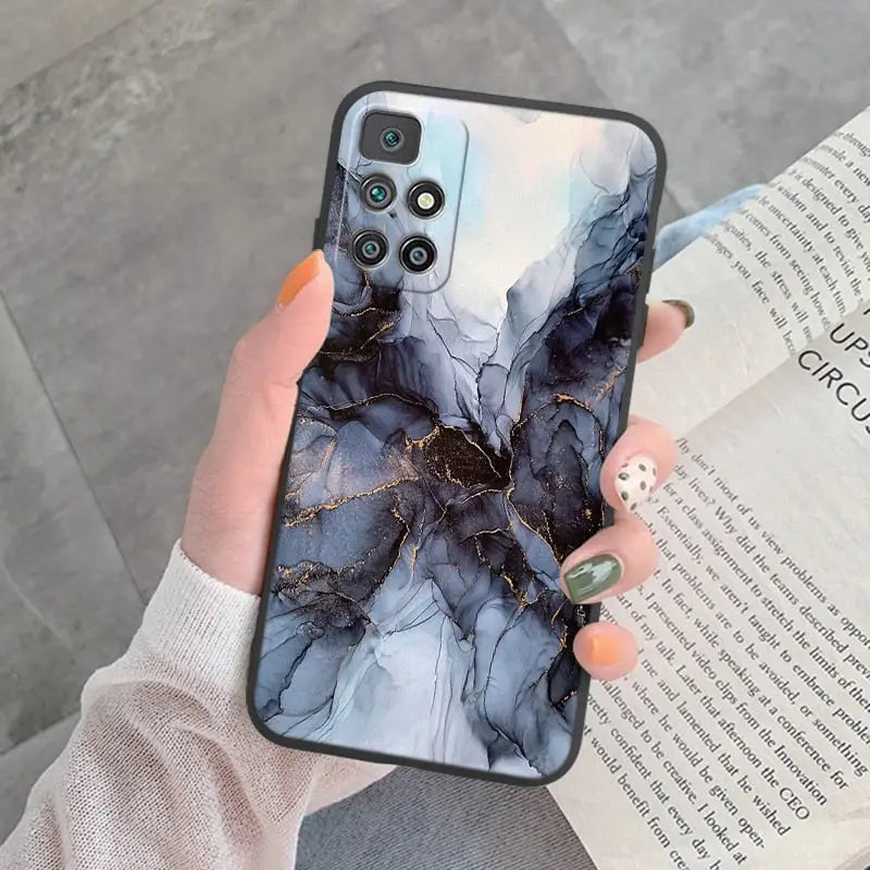 a woman holding a phone case with a marble pattern