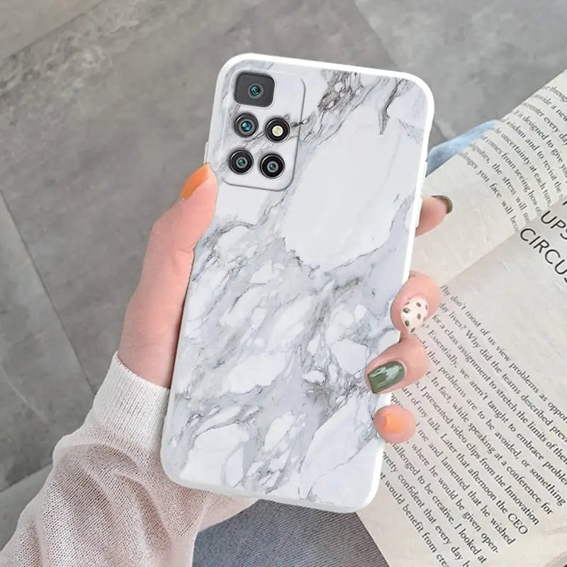 a woman holding a white marble phone case