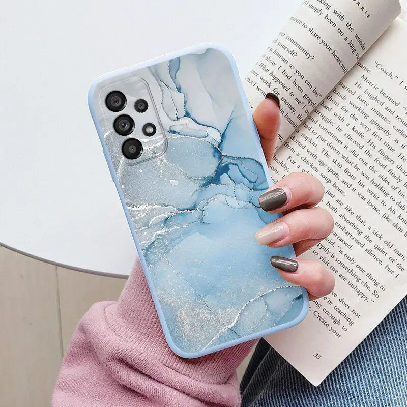 a woman holding a book and holding a phone case