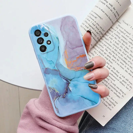 a woman holding a book and holding a phone case