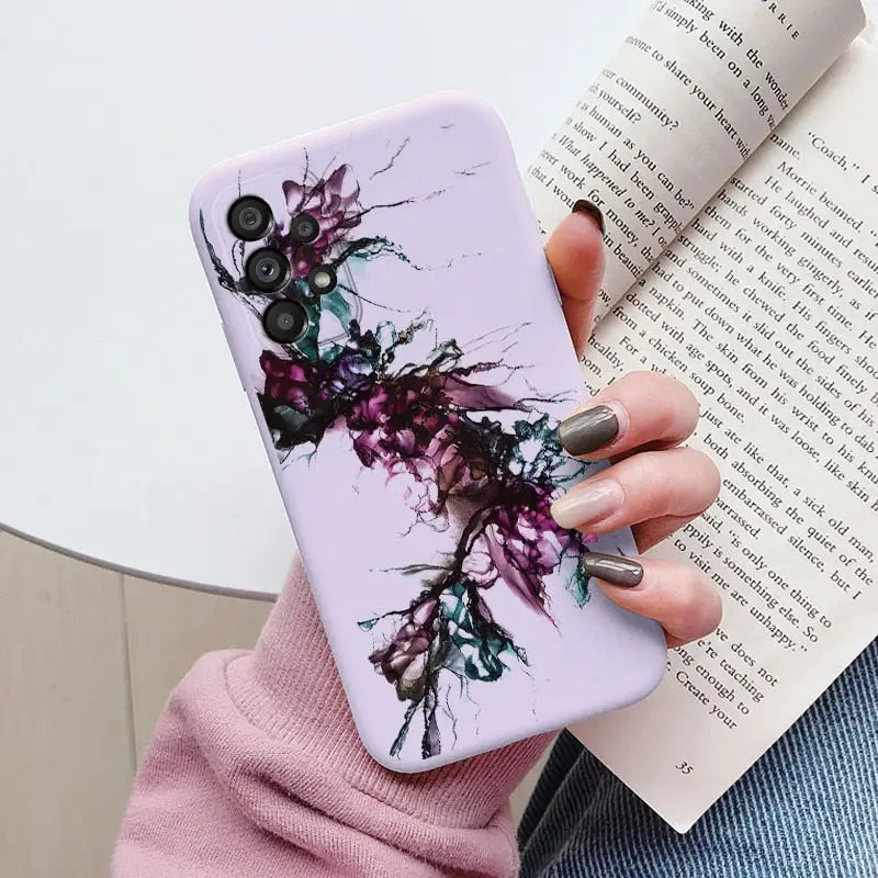 a woman holding a book and a phone case