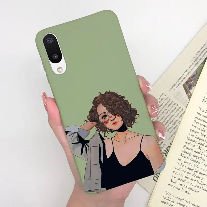 a woman holding a book and a phone case