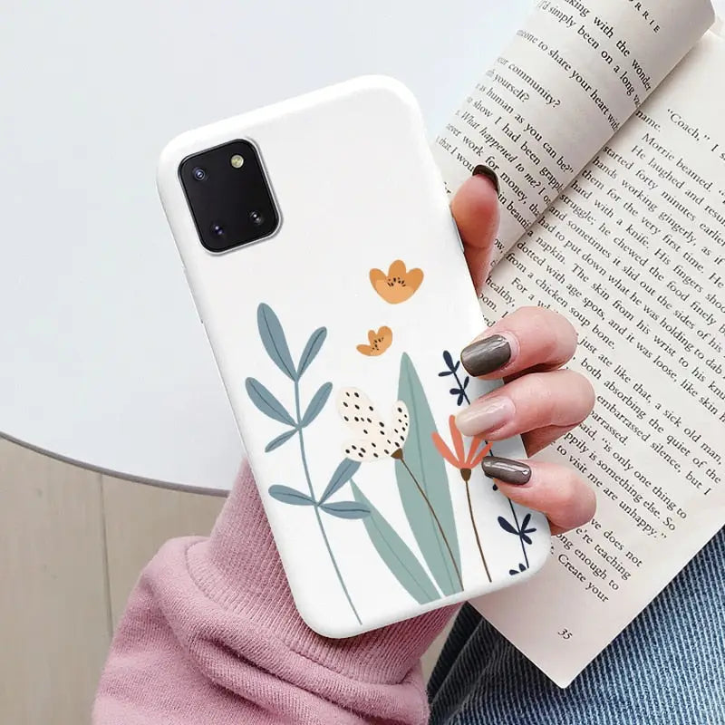 a woman holding a book and a phone case