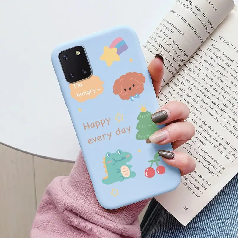 a woman holding a book and holding a phone case