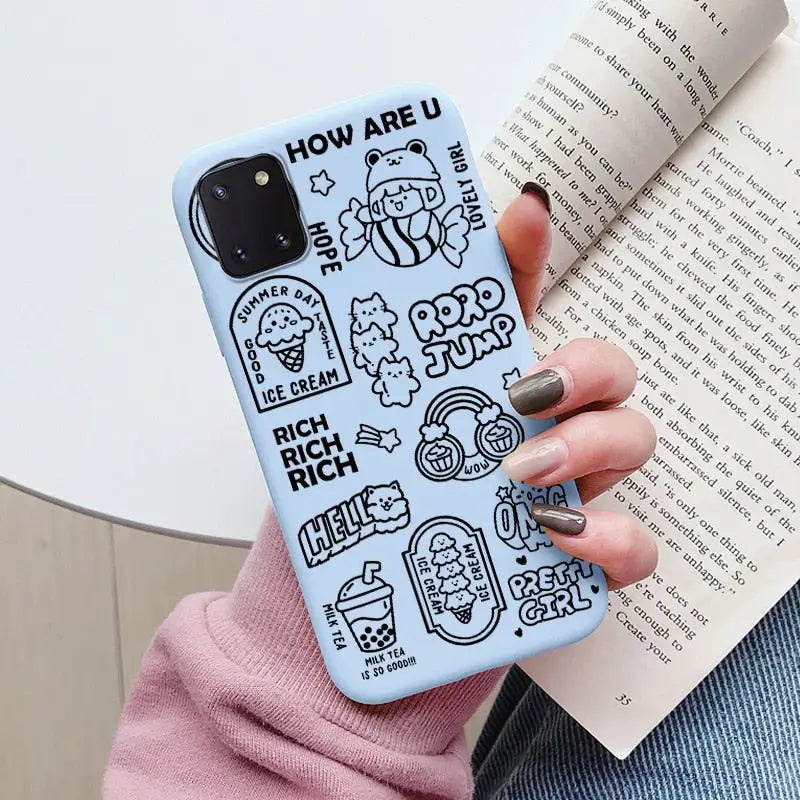 a woman holding a book and a phone case