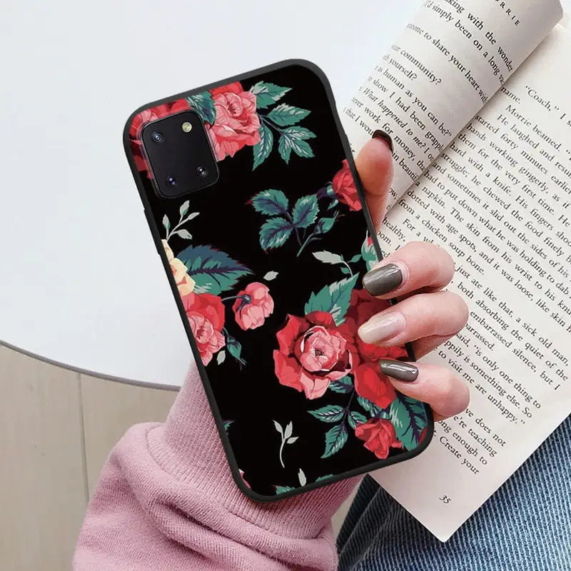 a woman holding a book and a phone case
