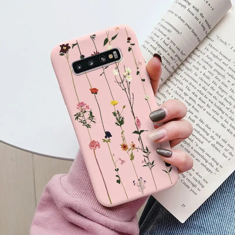 a woman holding a book and a pink phone case