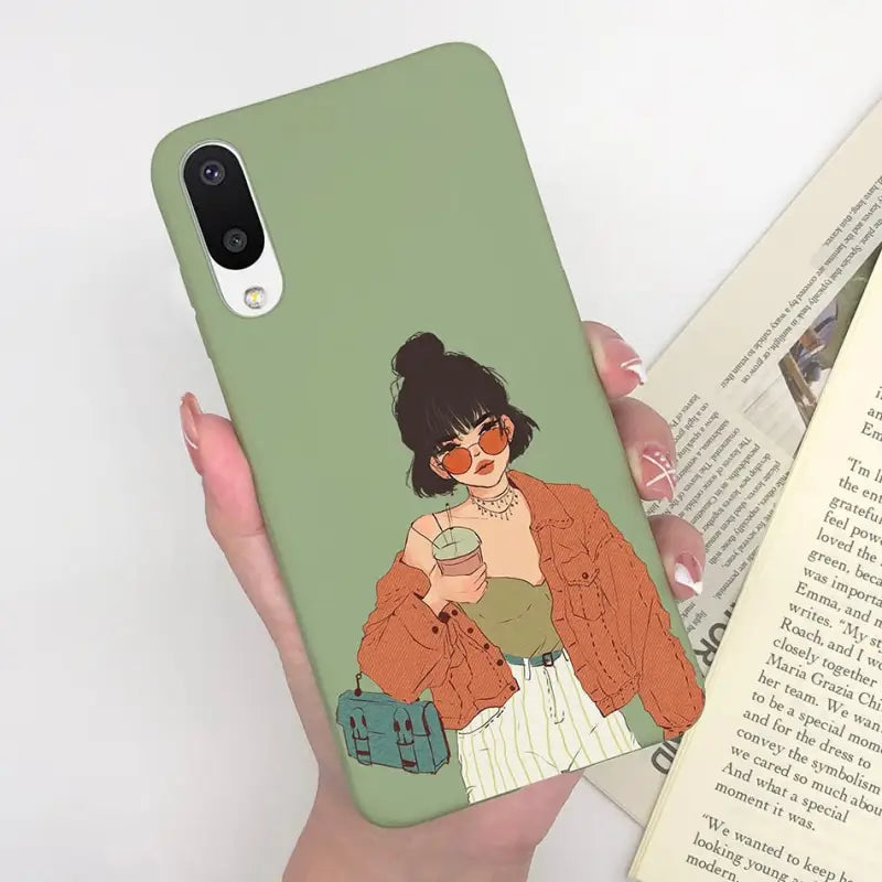 a woman holding a book and a phone case