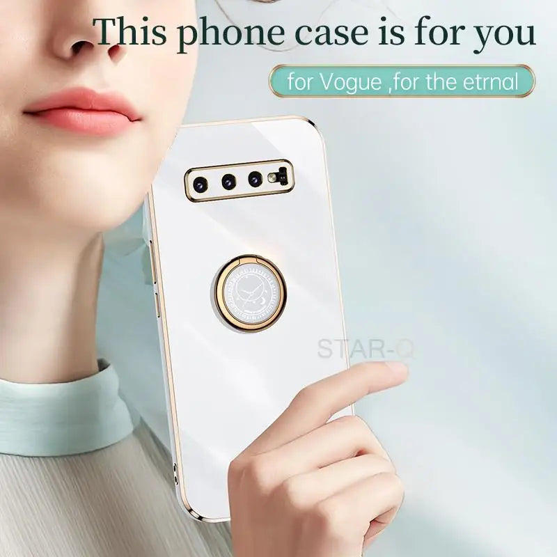 a woman holding a cell phone with a ring on it