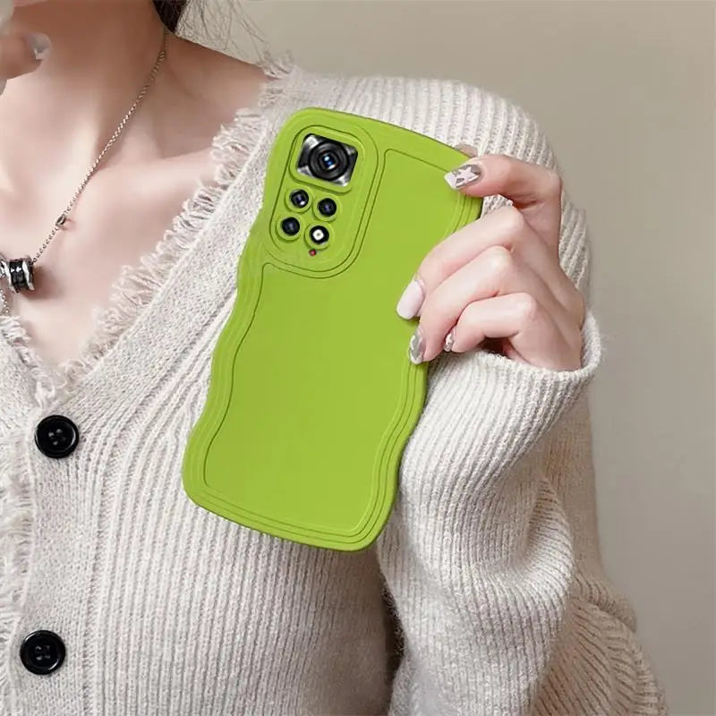 a woman holding a green phone case