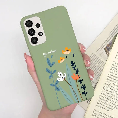 a woman holding a phone case with flowers on it