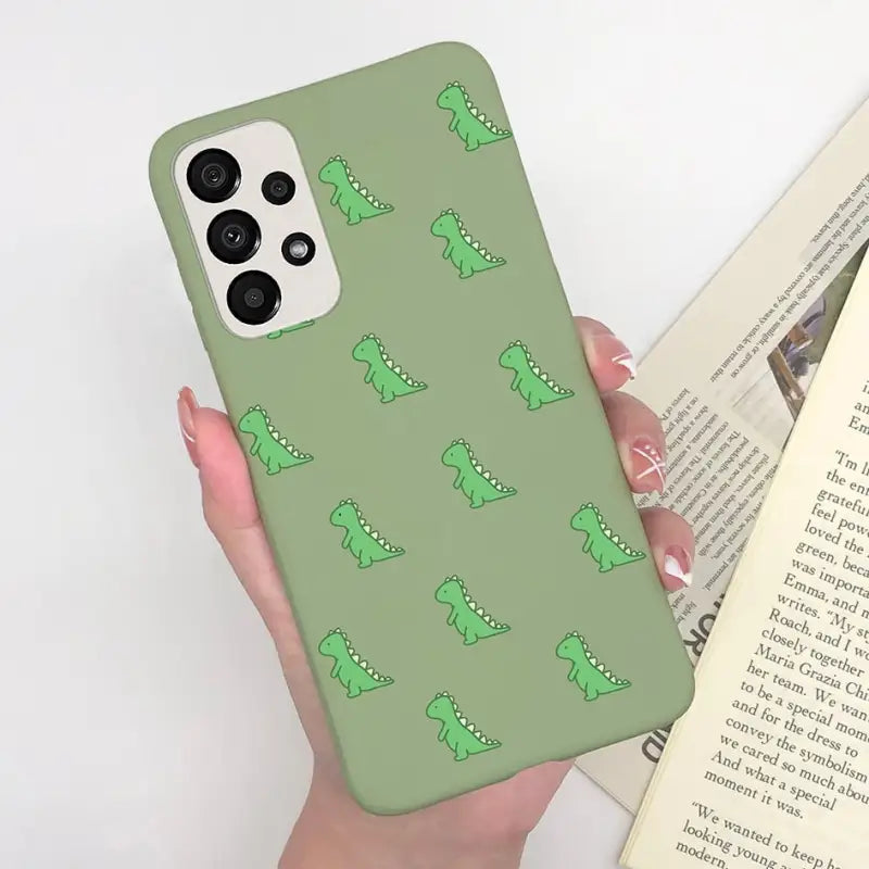 a woman holding a book and a green phone case