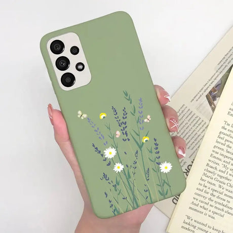a woman holding a book and a green phone case