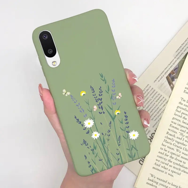 a woman holding a book and a phone case