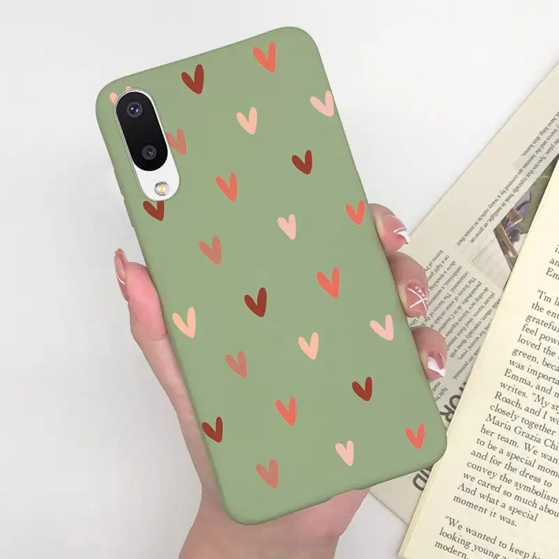 a woman holding a book and a phone case