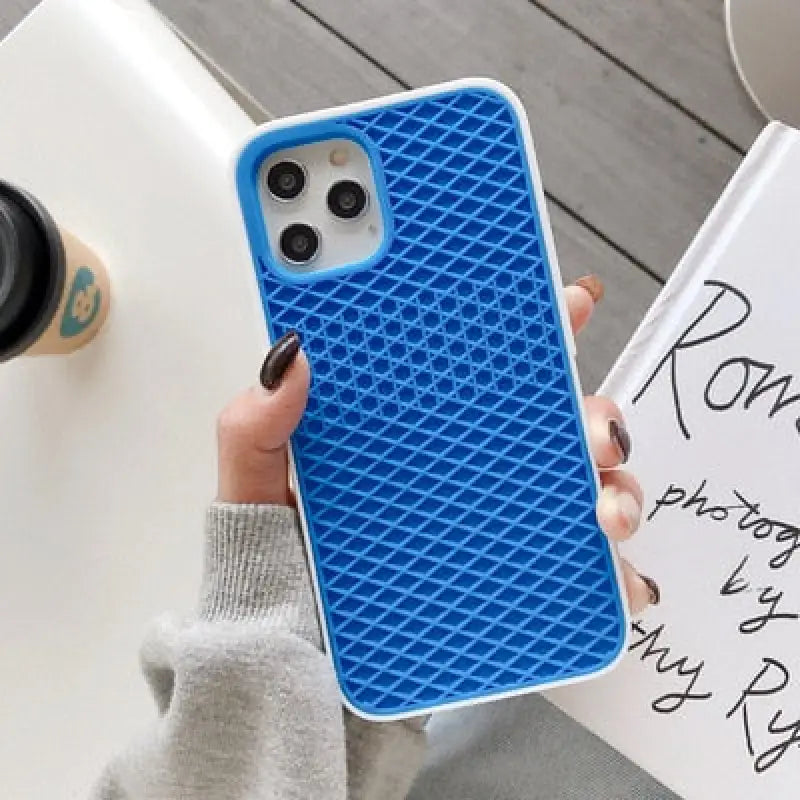 a woman holding a phone case with a blue pattern