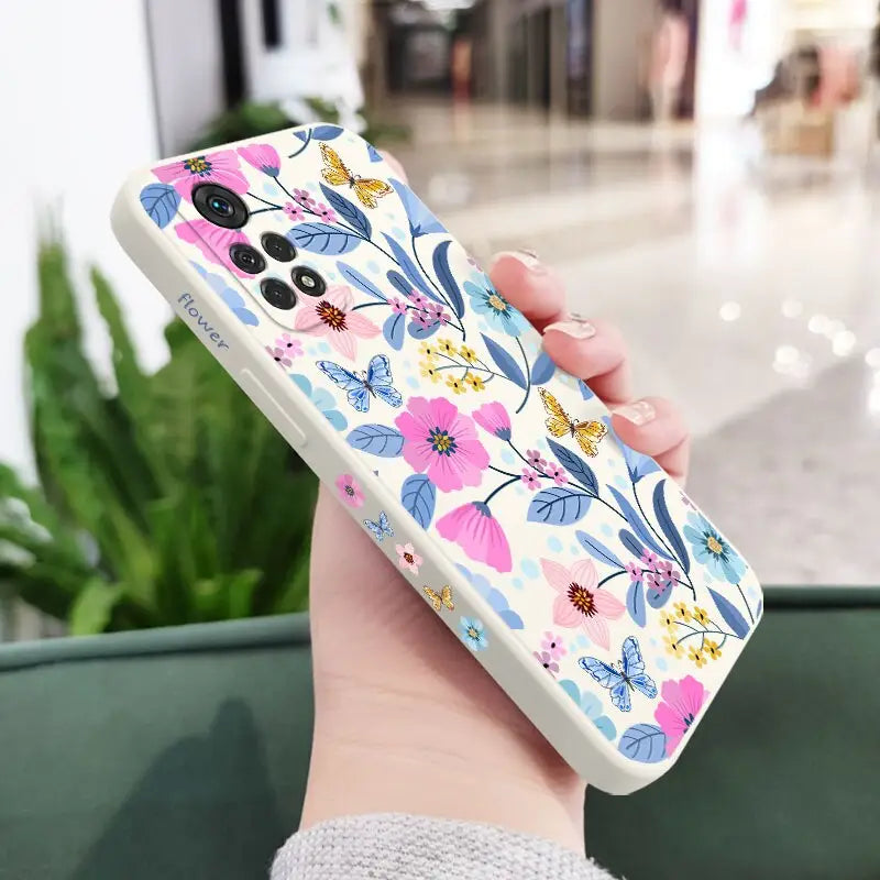a woman holding a phone case with flowers on it