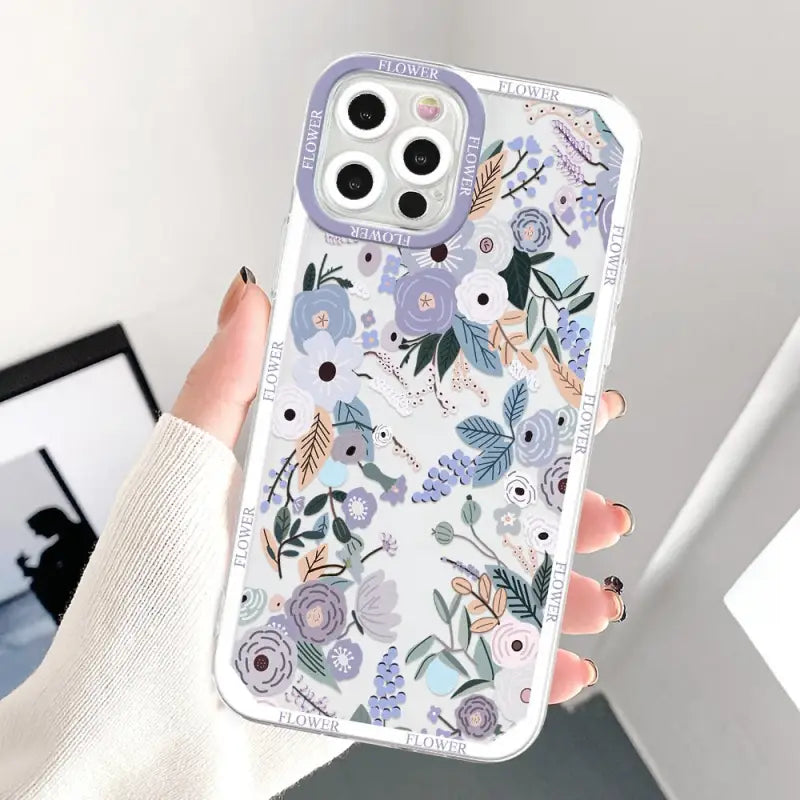 a woman holding a phone case with flowers on it