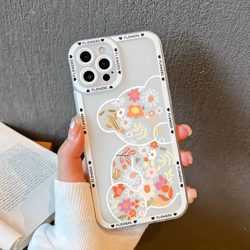 a woman holding a phone case with a floral pattern