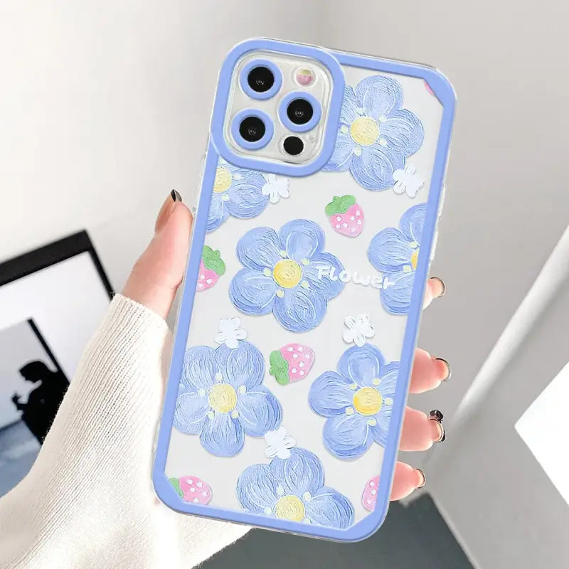 a woman holding a phone case with flowers on it