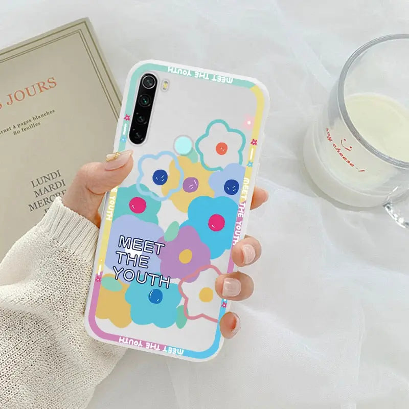 a woman holding a phone case with a colorful pattern