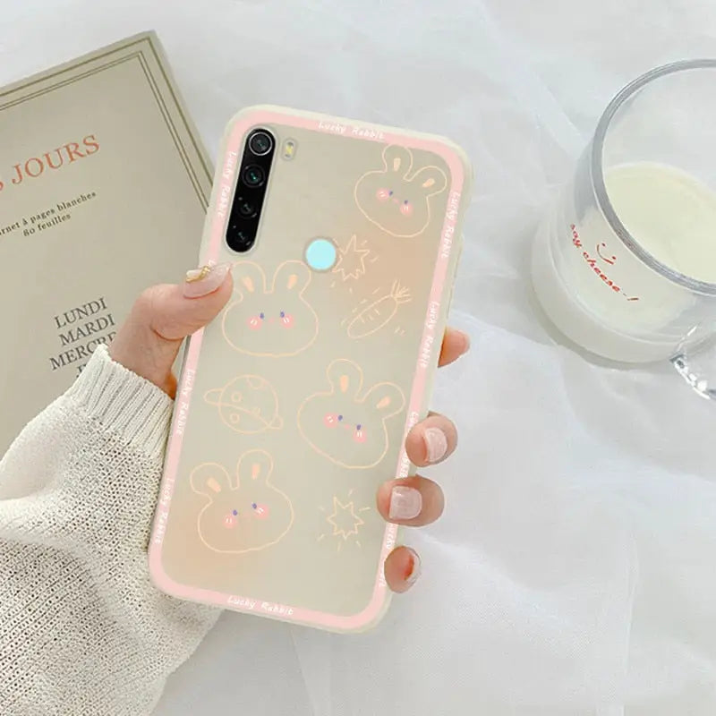 a woman holding a phone case with a pink and white pattern