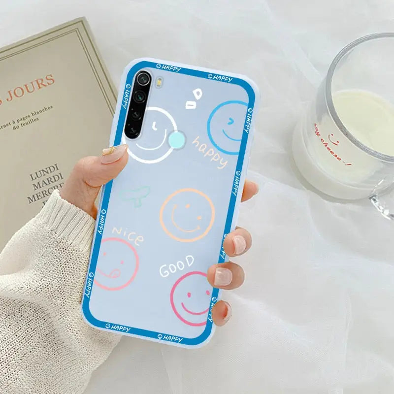 a woman holding a phone case with a smiley face on it