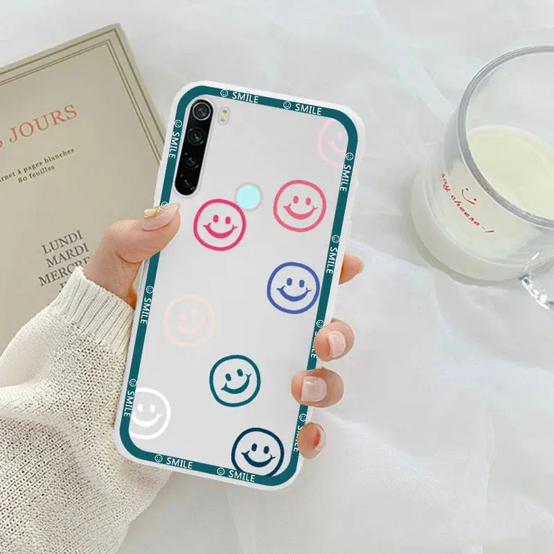 a woman holding a phone case with smiley faces on it