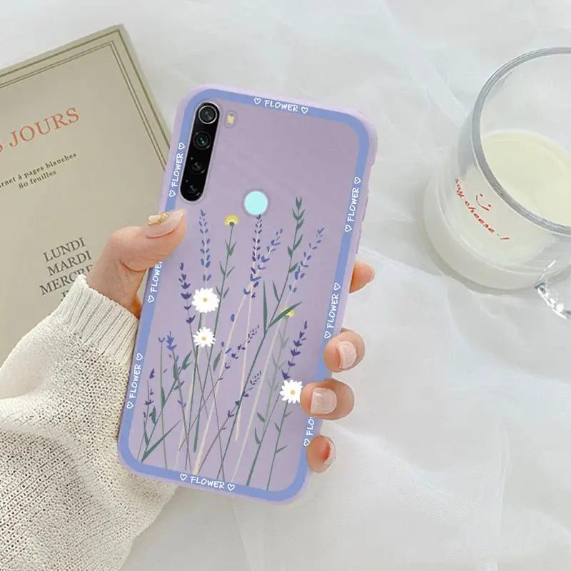 a woman holding a phone case with flowers on it