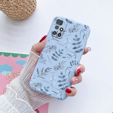 a woman holding a phone case with a floral pattern