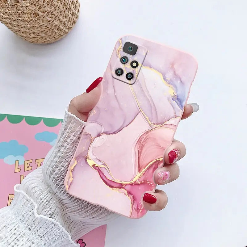 a woman holding a phone case with a pink marble pattern