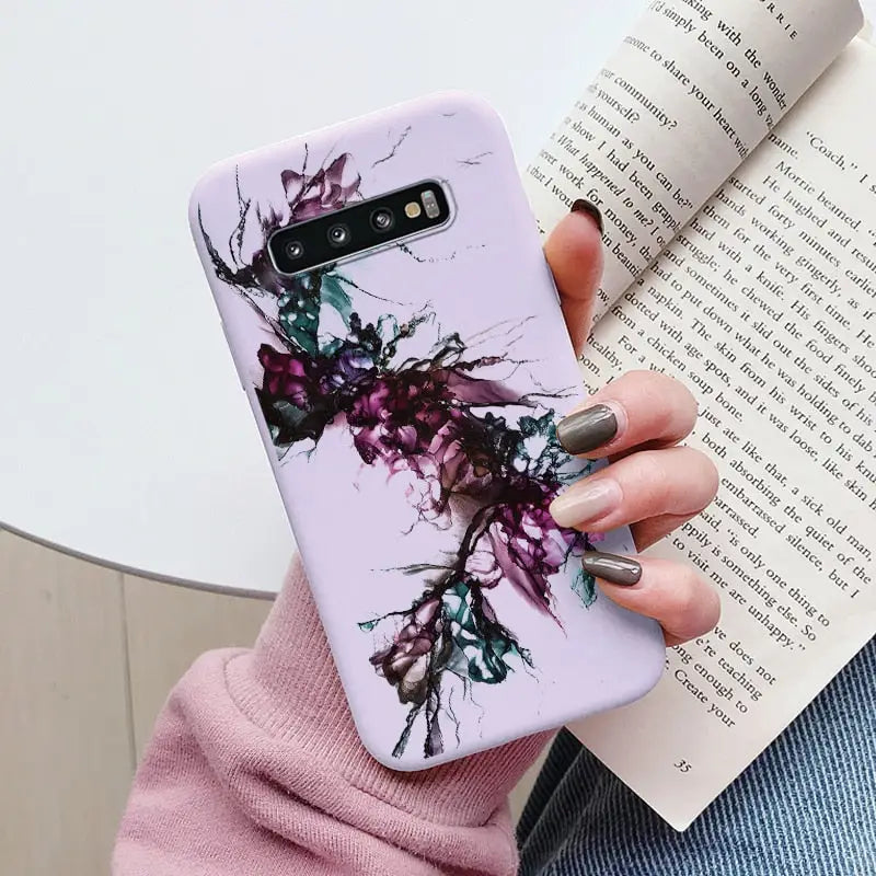 a woman holding a phone case with a purple flower design