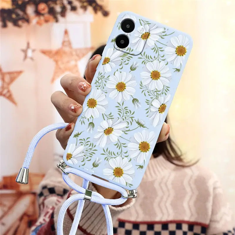 a woman holding a phone case with flowers on it