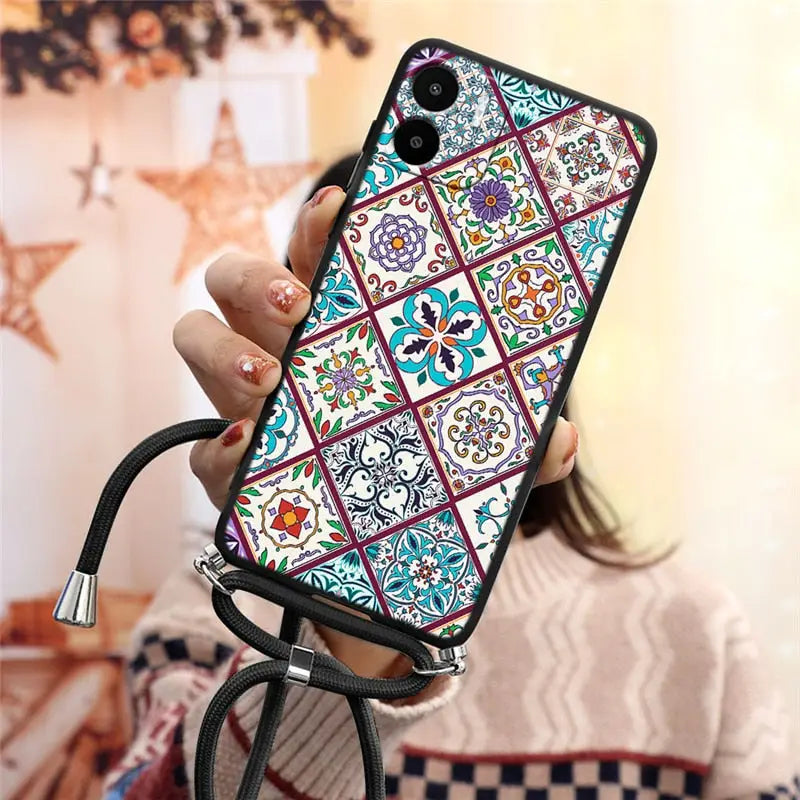 a woman holding a phone case with a colorful pattern