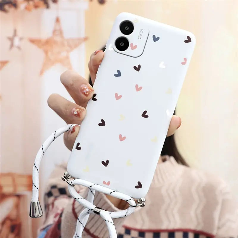 a woman holding a phone case with hearts on it