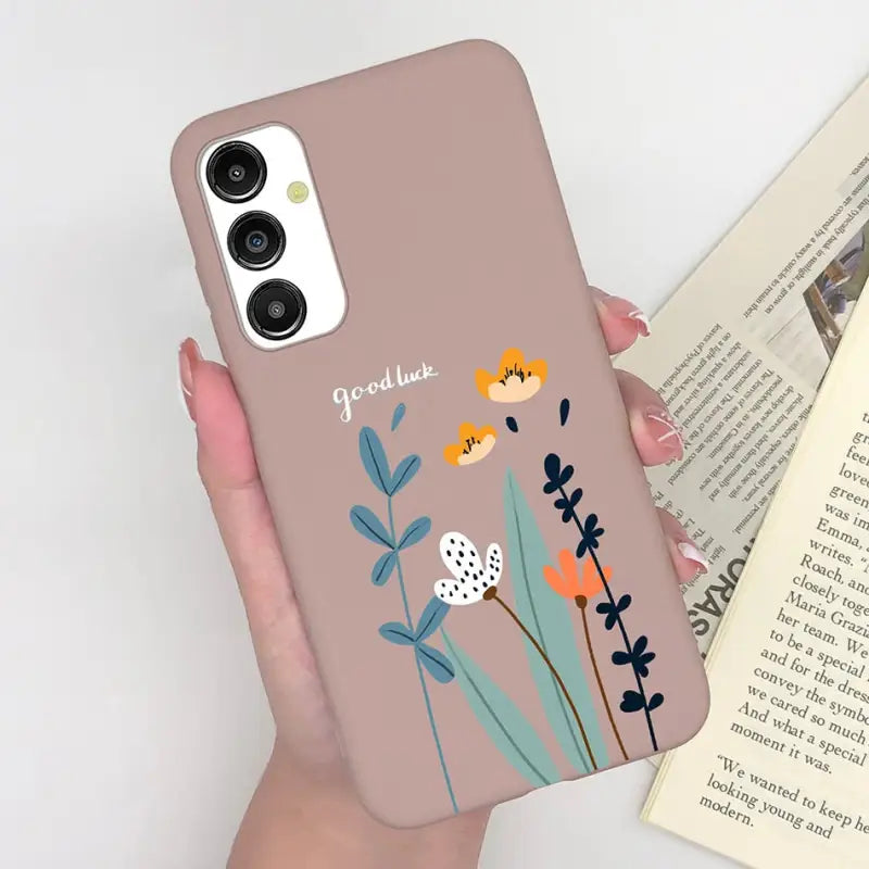 a woman holding a phone case with flowers on it