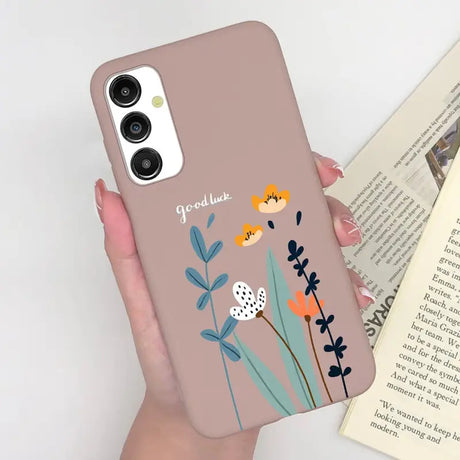 a woman holding a phone case with flowers on it