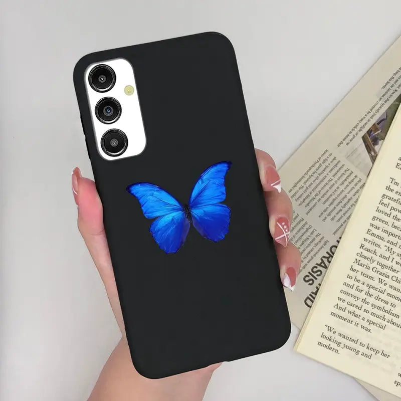 a woman holding a phone case with a blue butterfly on it