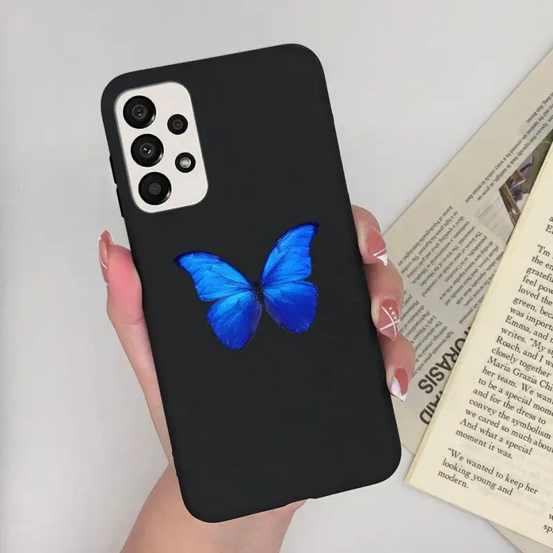 a woman holding a phone case with a blue butterfly on it