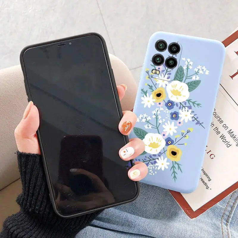 a woman holding a phone case with flowers on it