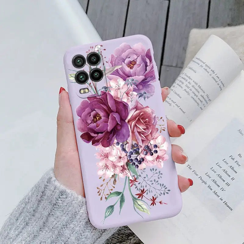 a woman holding a phone case with flowers on it