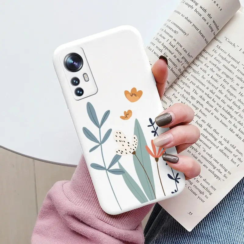 a woman holding a phone case with a flower design