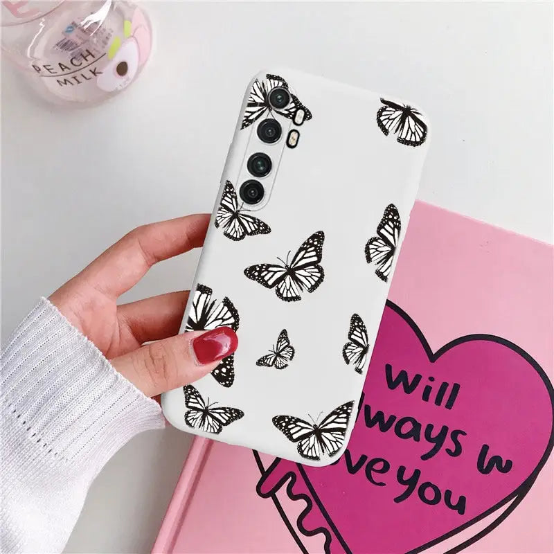 a woman holding a phone case with butterflies on it