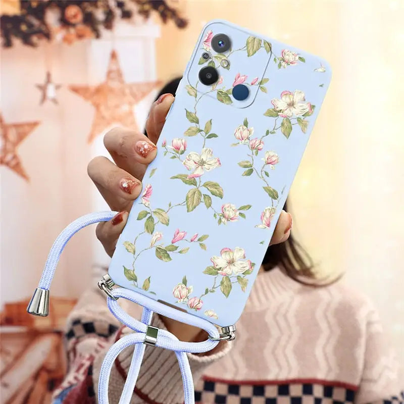 a woman holding a phone case with flowers on it