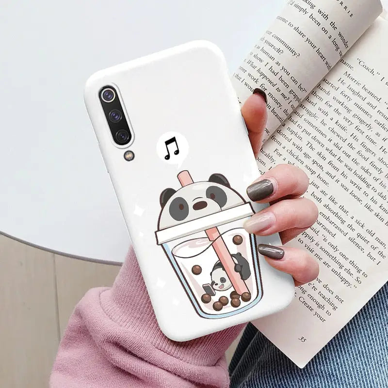 a woman holding a phone case with a cartoon character