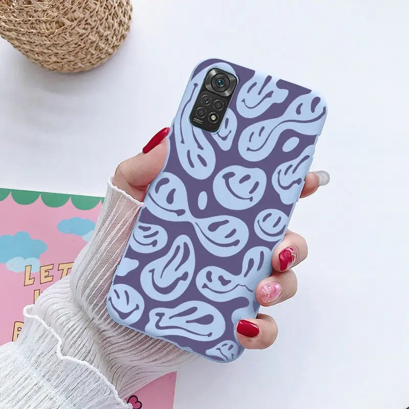 a woman holding a phone case with a pattern on it