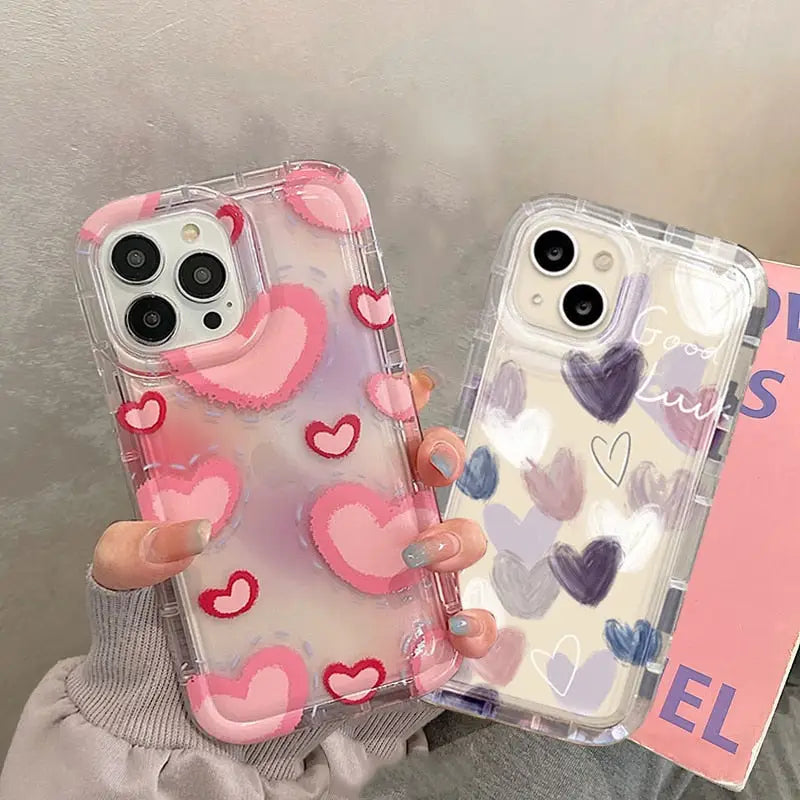 a woman holding a phone case with hearts on it