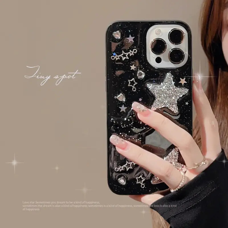 a woman holding a phone case with stars and planets