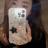 a woman holding a phone with a black and white glitter case